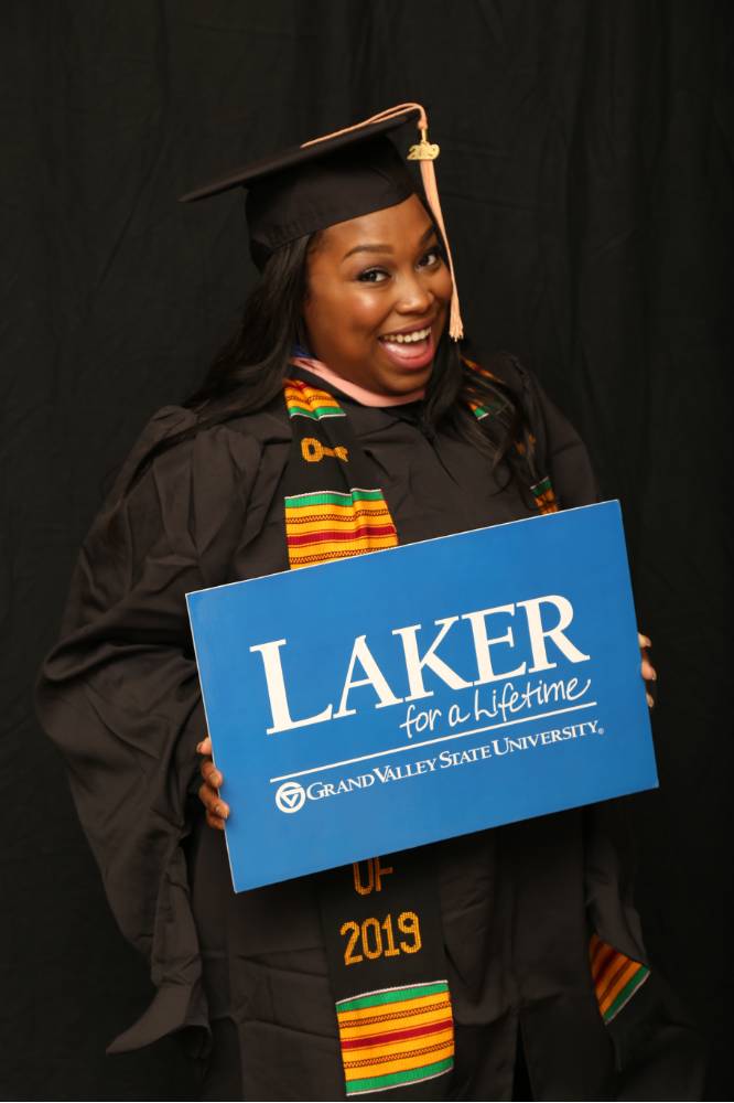 woman smiling with laker for a lifetime sign at GradFest photobooth